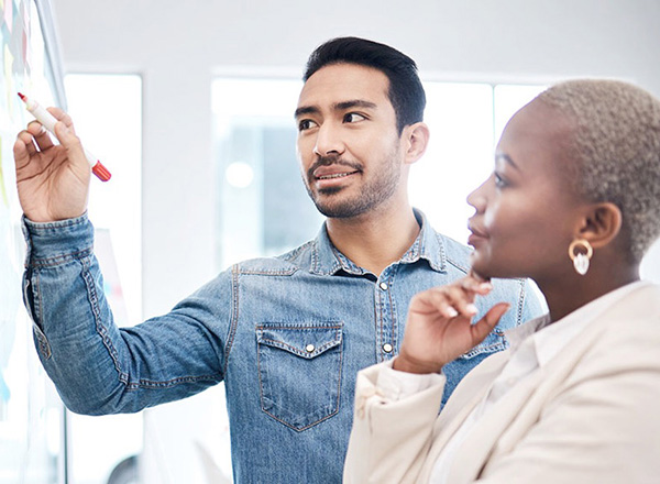 Woman and man looking at a white board