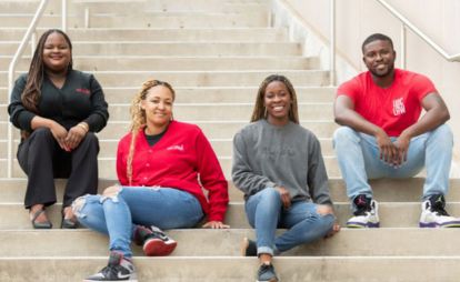  Four students sitting on the steps of a building