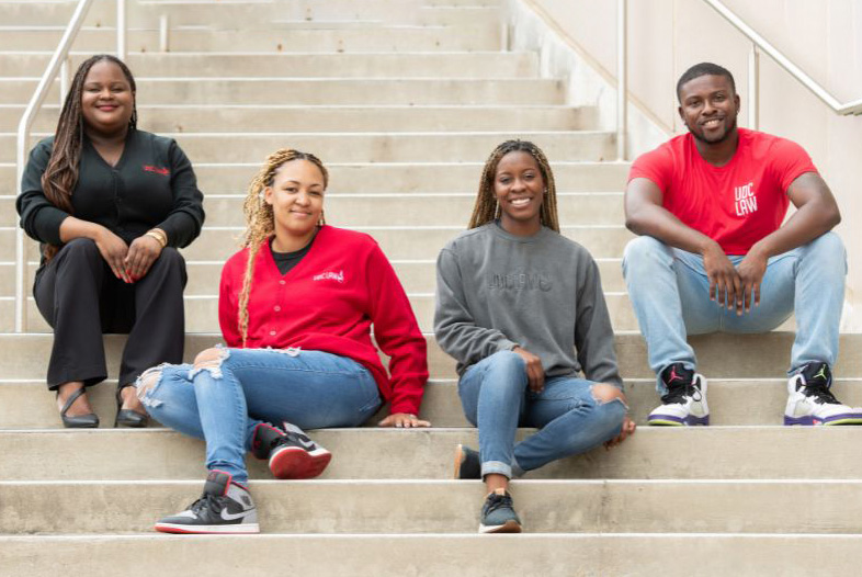 two female and two male 亚洲博彩网站 law students stilling on steps