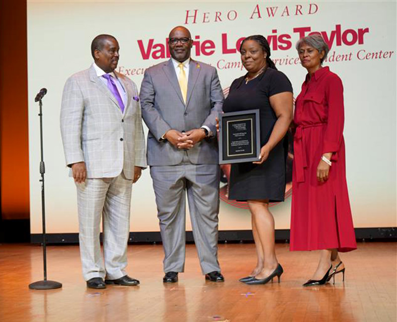 Valerie Lewis-Taylor holding a certificate of honor