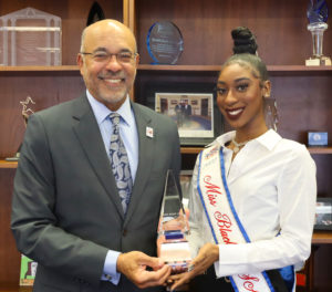The reigning Miss Black USA, Tahira Gilyard, presents a gift to 总统 Ronald Mason Jr.
